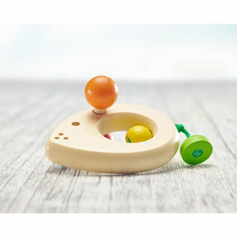 Nachhaltiges Holzspielzeug für Kleinkinder mit bunten Kugeln auf hellem Holzhintergrund