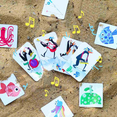 Bunte Spielkarten mit musizierenden Tieren auf Sand, ideal für kinderfreundliches, nachhaltiges Spielzeug